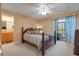 Comfortable main bedroom featuring an ensuite bathroom, ceiling fan, and outdoor balcony at 1130 N Lake Parker Ave # C321, Lakeland, FL 33805