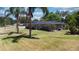 Charming single-story home with a well-manicured lawn and beautiful palm trees at 1195 E George St, Bartow, FL 33830