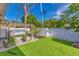 Fenced backyard featuring artificial grass, gravel, and garden area with a pergola at 1210 Marrick Cir, Lakeland, FL 33815