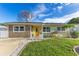 Charming single-story home featuring a stone facade, a well-manicured lawn, and a bright yellow front door at 1210 Marrick Cir, Lakeland, FL 33815