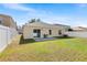 Spacious backyard with a well-kept lawn, white vinyl fence, and a patio area for outdoor enjoyment at 1216 Myopia Hunt Club Dr, Auburndale, FL 33823