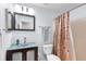 Bathroom with a glass vessel sink, bronze fixtures, decorative mirror, and framed shower curtain at 1216 Myopia Hunt Club Dr, Auburndale, FL 33823