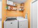 Laundry room includes washer, dryer, wire shelving, and hanging rack at 1216 Myopia Hunt Club Dr, Auburndale, FL 33823