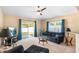 Cozy living room with sliding glass doors, a dark sofa and two windows bring in natural light at 1216 Myopia Hunt Club Dr, Auburndale, FL 33823