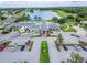 An aerial view shows the club house, parking lot, and American flag with a pond and golf course in the background at 1295 Osprey Landing Dr, Lakeland, FL 33813