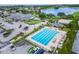 An aerial view of the pool and clubhouse shows a parking lot and golf course in the background at 1295 Osprey Landing Dr, Lakeland, FL 33813