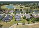 An aerial view showcases the homes with pools, green lawns, and a golf course with a lake nearby at 1295 Osprey Landing Dr, Lakeland, FL 33813