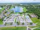 An aerial view showcases the community's clubhouse, pool, tennis courts, parking lot, and lake at 1295 Osprey Landing Dr, Lakeland, FL 33813