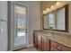 Bathroom featuring a granite vanity top, dark wood cabinets, and view to the pool outside at 1295 Osprey Landing Dr, Lakeland, FL 33813