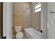 Bright bathroom featuring neutral tile in shower and floors, standard white tub and toilet at 1295 Osprey Landing Dr, Lakeland, FL 33813