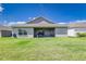 Lawn view of home exterior with covered patio and backyard grill at 1297 Pintail Pl, Lakeland, FL 33813