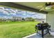 View from the covered patio to the expansive backyard with green lawn and neighborhood homes at 1297 Pintail Pl, Lakeland, FL 33813