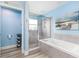 Bathroom features a tub shower combo, granite countertops, and stylish wood-look floors at 1297 Pintail Pl, Lakeland, FL 33813