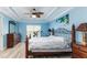 Inviting bedroom boasts natural light, blue walls, a ceiling fan, and wood-look floors at 1297 Pintail Pl, Lakeland, FL 33813