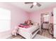 Pink bedroom includes wood flooring, white furniture, a ceiling fan, and ensuite bathroom at 1297 Pintail Pl, Lakeland, FL 33813