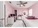 Pink bedroom features wood floors, a white dresser, and a ceiling fan at 1297 Pintail Pl, Lakeland, FL 33813
