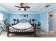Bright bedroom features blue walls, wood flooring, ceiling fan, and a decorative wrought iron bed frame at 1297 Pintail Pl, Lakeland, FL 33813