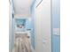 Hallway leading to bathroom featuring blue walls, wood floors and a door for storage at 1297 Pintail Pl, Lakeland, FL 33813