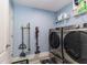 Functional laundry room with new washer and dryer units and shelving for storage at 1297 Pintail Pl, Lakeland, FL 33813