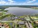Gorgeous aerial view showcasing lakefront community amenities, golf course, and tennis courts near a picturesque lake at 1394 Oakmont Dr, Winter Haven, FL 33884