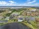 High-angle aerial view of a community showcasing pools, lakes, a golf course, and many homes at 1394 Oakmont Dr, Winter Haven, FL 33884