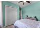 Bright bedroom with white bi-fold doors, ceiling fan, rustic dresser, and a calming aqua color scheme at 1394 Oakmont Dr, Winter Haven, FL 33884