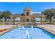 Scenic community entrance with fountain and 'Lake Ashton' sign is framed by lush landscaping and blue skies at 1394 Oakmont Dr, Winter Haven, FL 33884