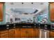 Stylish kitchen featuring dark granite countertops, stainless steel appliances, and light wood cabinets at 1394 Oakmont Dr, Winter Haven, FL 33884