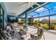 Screened-in lanai with ceiling fans, comfortable seating, an outdoor kitchen, and garden views at 1394 Oakmont Dr, Winter Haven, FL 33884