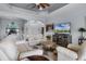 Spacious living room featuring a large sectional, ceiling fan, and entertainment center at 1394 Oakmont Dr, Winter Haven, FL 33884