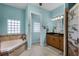 Inviting main bathroom with a large vanity, granite countertop, soaking tub, and decorative finishes at 1394 Oakmont Dr, Winter Haven, FL 33884