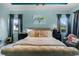 Light-filled main bedroom boasts tray ceiling, ceiling fan, accent lighting, and two windows at 1394 Oakmont Dr, Winter Haven, FL 33884