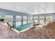 Inviting indoor pool area with brick flooring and large windows overlooking a scenic view at 1394 Oakmont Dr, Winter Haven, FL 33884