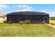 Well-manicured backyard is lush and green with a spacious screened-in patio perfect for outdoor living at 1394 Oakmont Dr, Winter Haven, FL 33884