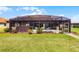 A large, well-maintained backyard is visible behind the screened-in patio area with a hot tub at 1394 Oakmont Dr, Winter Haven, FL 33884