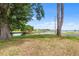 Beautiful backyard with dock, lush green grass, mature trees, and serene water views at 145 Jana Cir, Auburndale, FL 33823