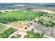 Picturesque aerial view highlighting a property with a mix of wooded areas, open fields, and small bodies of water at 14810 Brahma Rd, Polk City, FL 33868