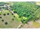 Aerial view featuring the serene lot and its sprawling trees, providing privacy and a natural setting at 14810 Brahma Rd, Polk City, FL 33868