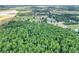 Aerial shot of a densely wooded lot and surrounding pastures at 14810 Brahma Rd, Polk City, FL 33868