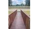 A wooden bridge leading to a property, bordered by fencing and lush greenery at 14810 Brahma Rd, Polk City, FL 33868