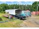 Exterior shot showing a black truck parked beneath a metal carport on a sunny day at 14810 Brahma Rd, Polk City, FL 33868