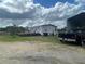 Exterior view of a well maintained mobile home with a wooden deck and a dark pickup truck in the driveway at 14810 Brahma Rd, Polk City, FL 33868