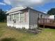 A home featuring gray siding, surrounded by a well-maintained lawn and mature trees at 14810 Brahma Rd, Polk City, FL 33868