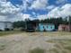 A wide exterior shot showing a light blue shed and a pickup truck under a canopy near a mobile home at 14810 Brahma Rd, Polk City, FL 33868