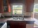 Kitchen featuring a double basin sink, cabinets, tile backsplash, and a view outside through the window at 14810 Brahma Rd, Polk City, FL 33868