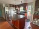 Kitchen featuring stainless steel refrigerator, dark wood cabinets, and an island with a dark counter at 14810 Brahma Rd, Polk City, FL 33868