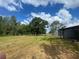 Grassy land with a barn in the background with mature trees at 14810 Brahma Rd, Polk City, FL 33868