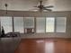 Bright living room with hardwood floors, ceiling fan and several windows offering natural light at 14810 Brahma Rd, Polk City, FL 33868