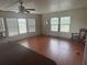 Spacious living room with wood flooring, multiple windows with blinds, and ceiling fan at 14810 Brahma Rd, Polk City, FL 33868