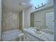 The bathroom features a vanity with white cabinets and a tub with tile surround at 1517 Leamington Ln, Winter Haven, FL 33884